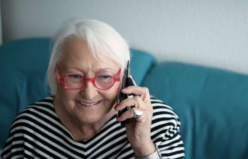 Ältere Dame mit Brille telefoniert